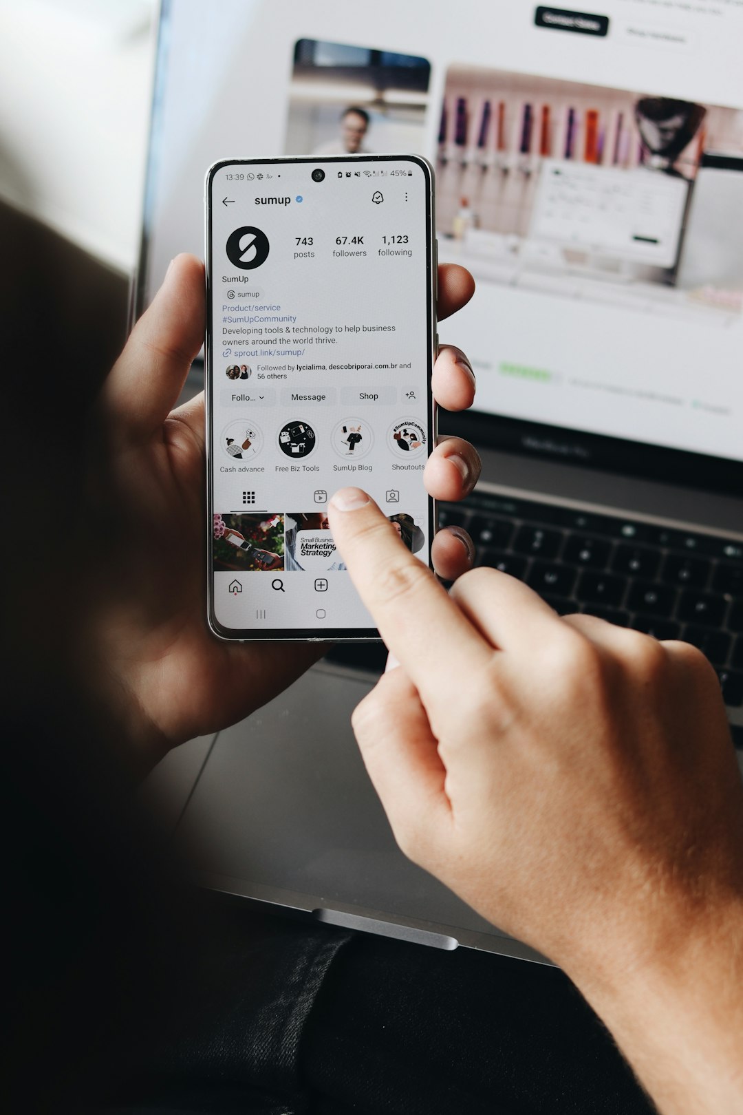 gallery-6 A person is holding a smartphone and browsing the SumUp Instagram profile.
